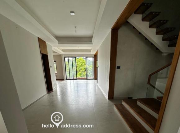 View as you enter through the main door, living room and stairs on the right, guest room on the left, and vast greenery from the balcony..